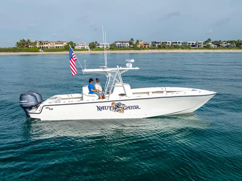Slide: The Image of 2014 SeaVee 34 boat on water, American flag, coastal homes in background. - 7