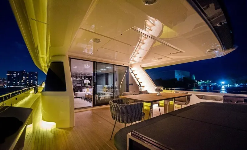 Slide: The Image of Luxurious 2018 Ferretti Yachts 850 Motoryacht deck at night, featuring elegant outdoor seating. - 5