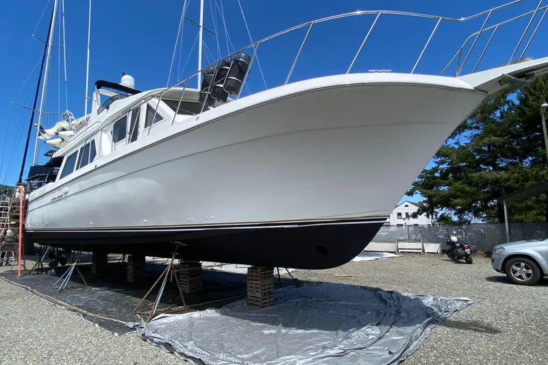 The Image of 1998 Navigator 5300 Classic yacht docked at marina with forest backdrop. - 0