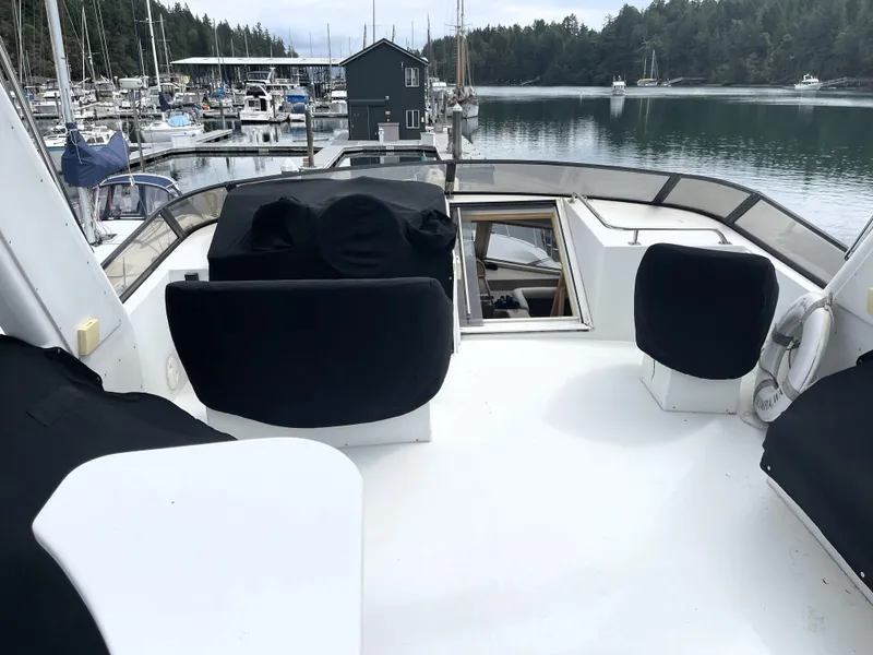 Slide: The Image of 1998 Navigator 5300 Classic yacht with white seating and table on deck, docked in marina. - 33