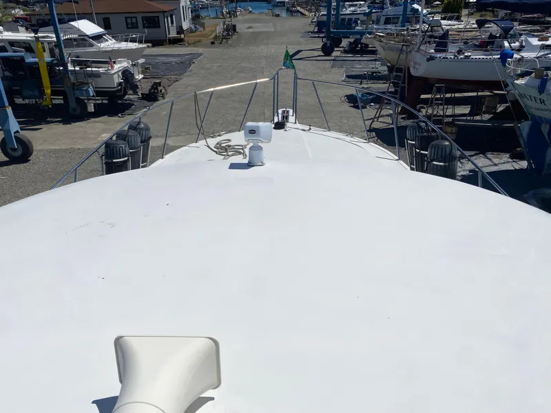 Slide: The Image of 1998 Navigator 5300 Classic yacht with covered seating, docked in a serene marina. - 35