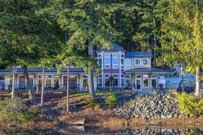 Slide: The Image of Luxurious lakeside house surrounded by lush trees, featuring large windows and a scenic view. - 47