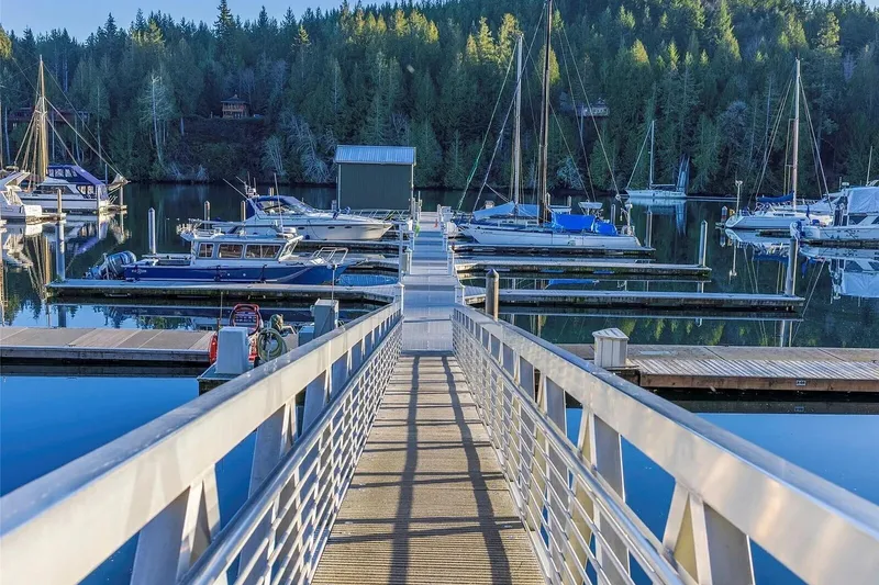 Slide: The Image of Marina with boats docked, featuring a 1998 Navigator 53 yacht, surrounded by lush forest. - 49