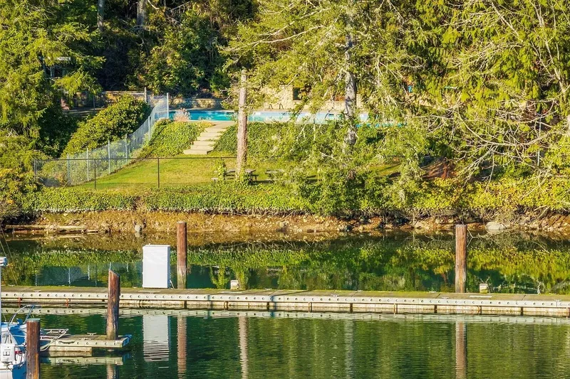 Slide: The Image of Scenic waterfront view with lush greenery and a dock, featuring a 1998 Navigator 53. - 50