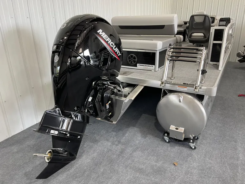Slide: The Image of 2025 Princecraft Vectra 21 RL pontoon boat with Mercury outboard motor in showroom. - 2