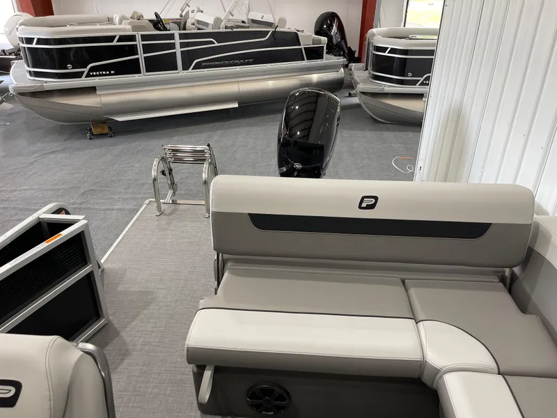 Slide: The Image of 2025 Princecraft Vectra 21 RL pontoon boat interior with seating and motor in showroom. - 8