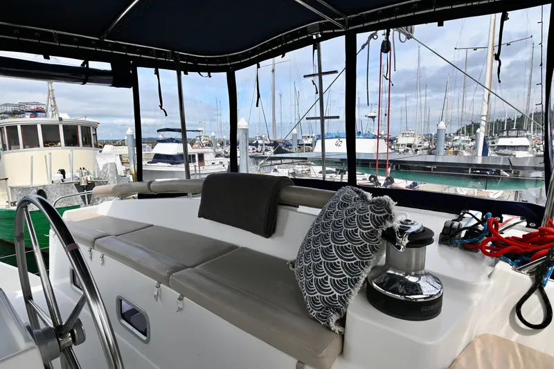Slide: The Image of Lagoon 440 catamaran cockpit view, 2009 model, with marina background and comfortable seating. - 10