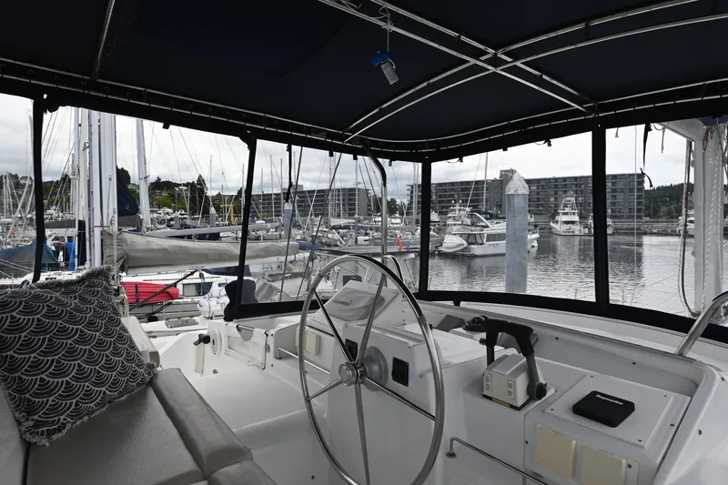 Slide: The Image of Interior view of 2009 Lagoon 440 catamaran helm, overlooking marina with docked boats. - 11
