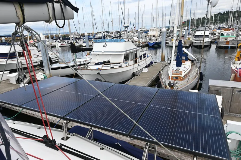 Slide: The Image of 2009 Lagoon 440 catamaran with solar panels docked at a marina. - 14