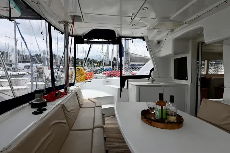 Slide: The Image of Interior of 2009 Lagoon 440 catamaran with seating and table, docked at marina. - 17
