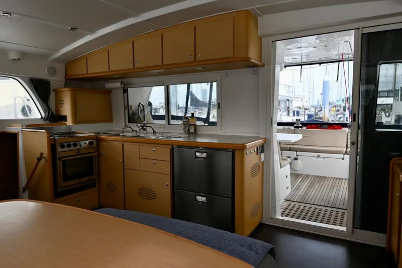 Slide: The Image of Interior of 2009 Lagoon 440 catamaran with modern kitchen and dining area. - 25