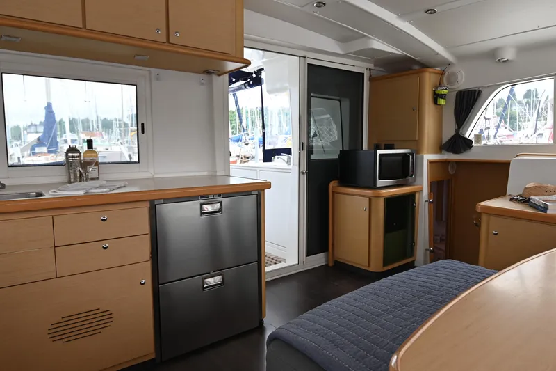 Slide: The Image of Interior of 2009 Lagoon 440 catamaran with modern kitchen and dining area. - 29