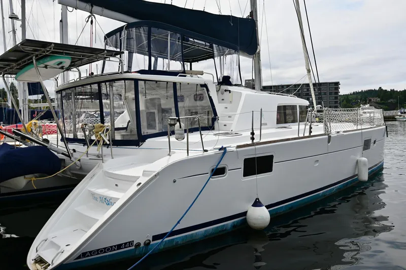 Slide: The Image of 2009 Lagoon 440 catamaran docked in marina, featuring sleek design and spacious deck. - 4