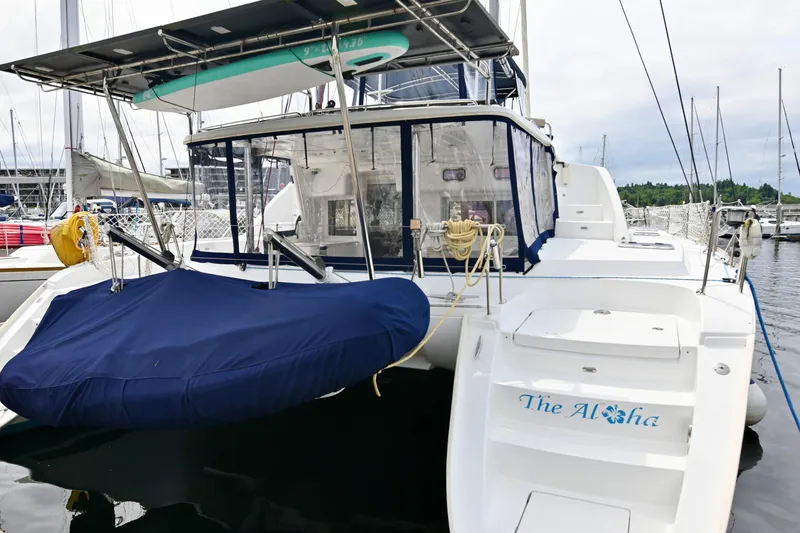 Slide: The Image of 2009 Lagoon 440 catamaran docked at marina, featuring covered seating and equipment. - 5