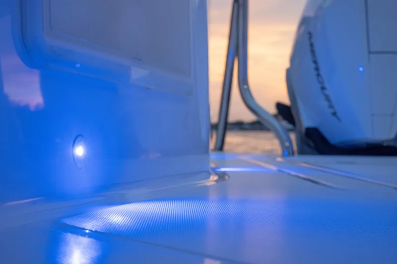 Slide: The Image of 2026 Axopar 45 Cross Top boat with blue LED lighting at sunset. - 46