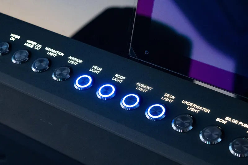Slide: The Image of Control panel of 2026 Axopar 45 Cross Top with illuminated light switches. - 36