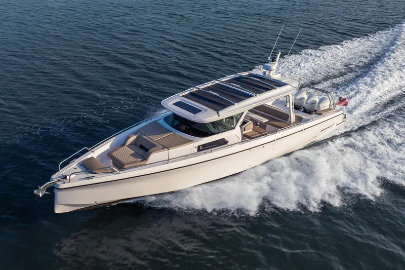 Slide: The Image of 2026 Axopar 45 Cross Top cruising on open water, showcasing sleek design and powerful engines. - 2