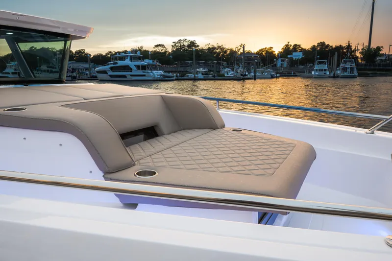 Slide: The Image of Luxurious seating on 2026 Axopar 45 Cross Top boat at sunset, docked in marina. - 21