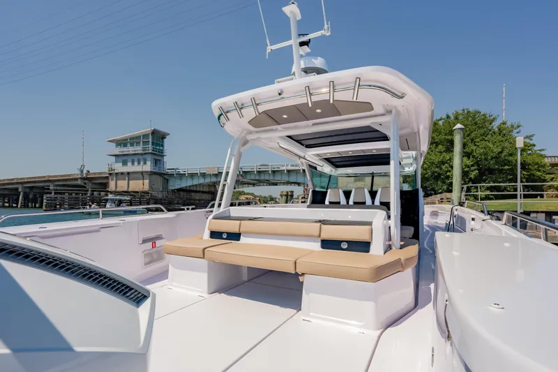 Slide: The Image of 2026 Axopar 45 Cross Top boat with sleek design, docked near a bridge. - 23