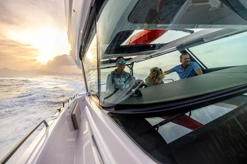 Slide: The Image of 2025 Axopar 45 Cross Top cruising at sunset with passengers enjoying the ride. - 4