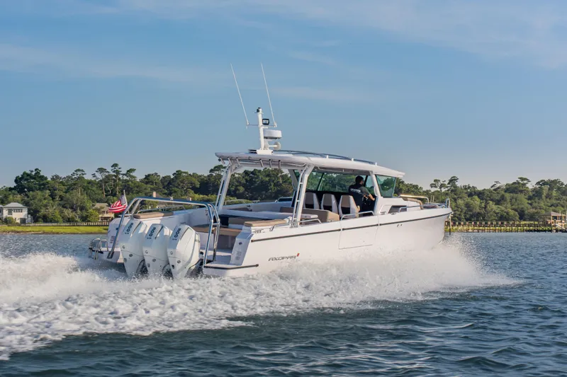 Slide: The Image of 2026 Axopar 45 Cross Top cruising on a scenic waterway with powerful engines. - 15