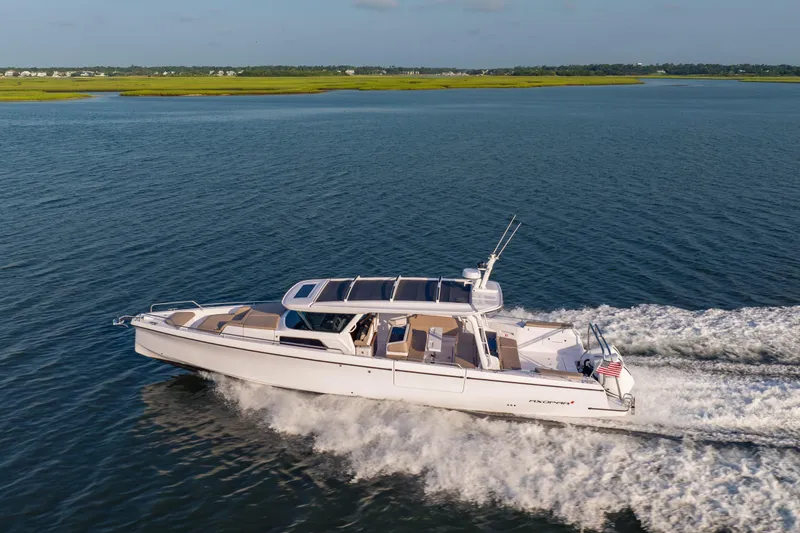 Slide: The Image of 2026 Axopar 45 Cross Top cruising on open water, showcasing sleek design and performance. - 6