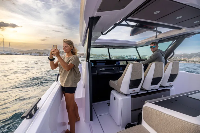 Slide: The Image of 2025 Axopar 45 Cross Top boat with passengers enjoying a scenic sunset cruise. - 5