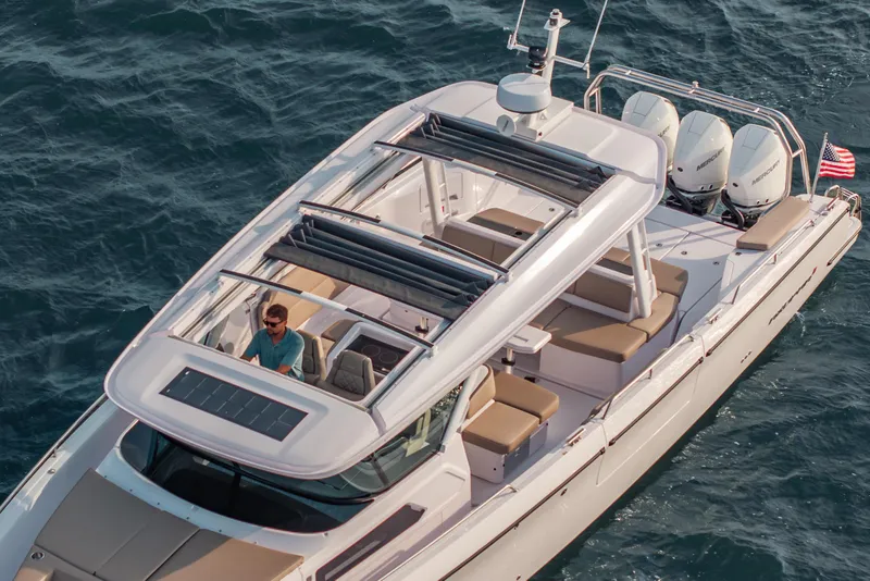 Slide: The Image of 2026 Axopar 45 Cross Top boat cruising on open water, featuring sleek design and powerful engines. - 16