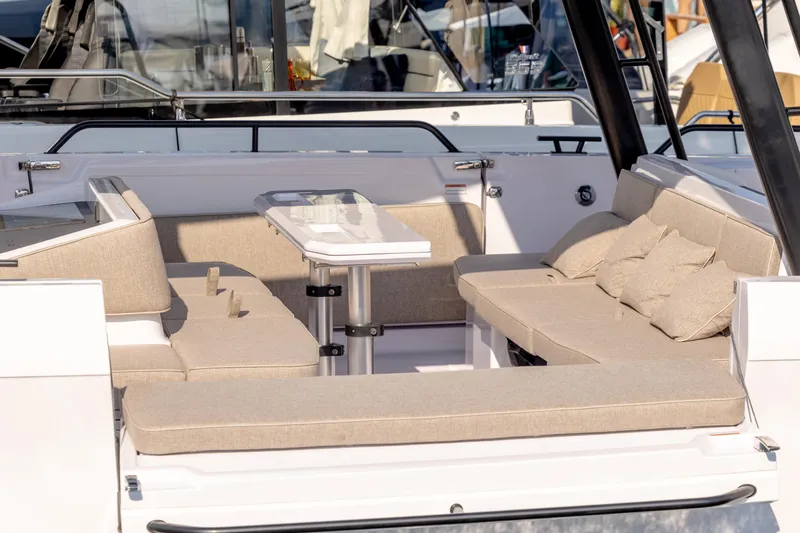 Slide: The Image of 2025 Axopar 45 Cross Top boat interior with beige seating and table. - 7