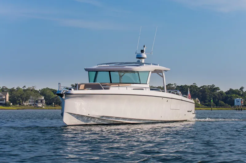 Slide: The Image of 2026 Axopar 45 Cross Top boat cruising on a calm lake with scenic background. - 4