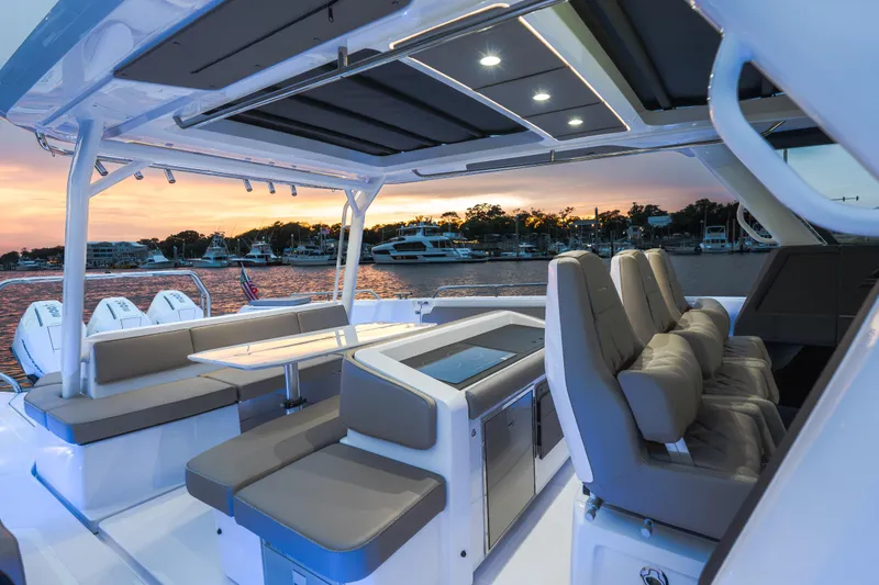 Slide: The Image of 2026 Axopar 45 Cross Top boat interior at sunset, featuring luxurious seating and modern design. - 29