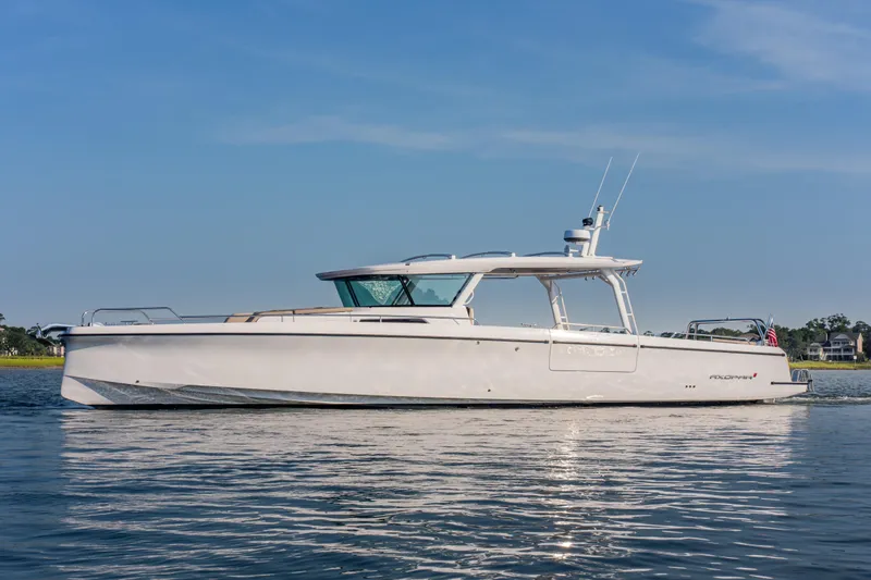 Slide: The Image of 2026 Axopar 45 Cross Top boat on calm water under clear blue sky. - 3