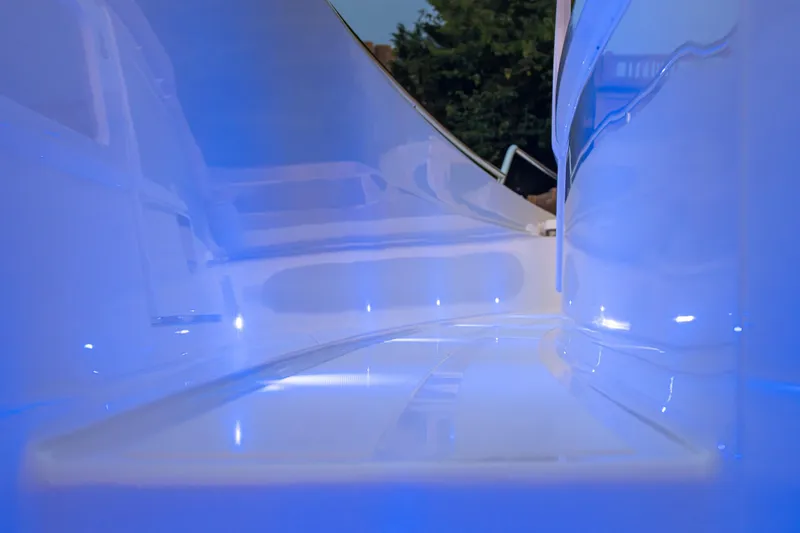 Slide: The Image of Interior view of 2026 Axopar 45 Cross Top boat with blue ambient lighting. - 47