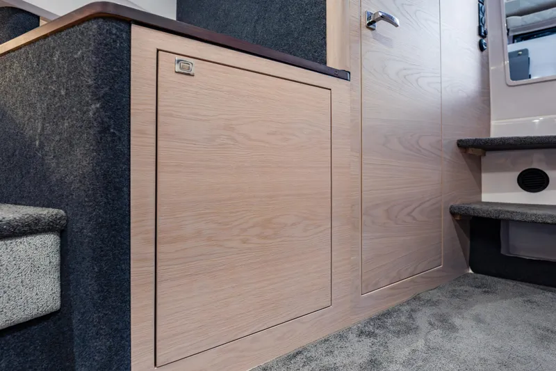 Slide: The Image of Interior of 2026 Axopar 45 Cross Top, featuring sleek wooden cabinetry and carpeted steps. - 59