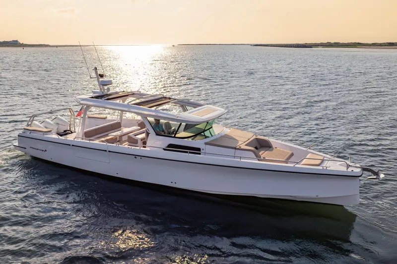 Slide: The Image of 2026 Axopar 45 Cross Top boat cruising on serene waters at sunset. - 13