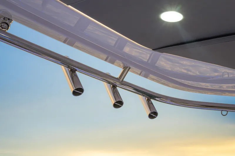 Slide: The Image of Close-up of Axopar 45 Cross Top 2026 boat's sleek metal railings at sunset. - 26