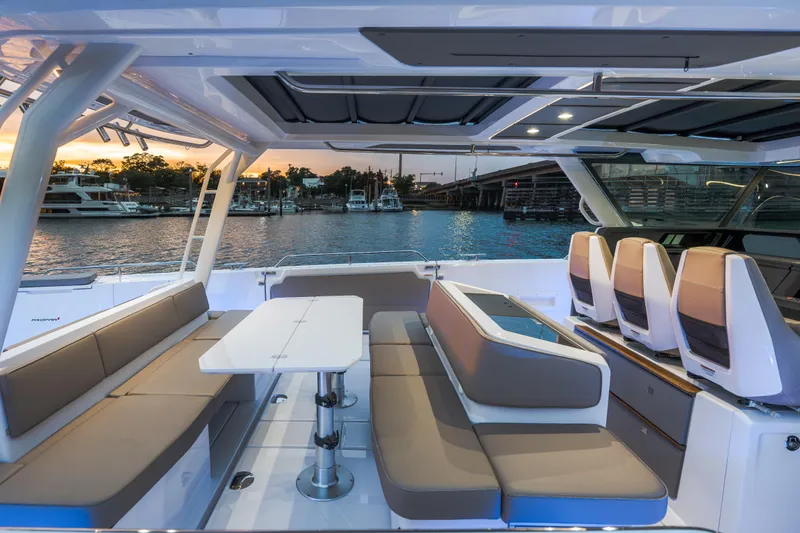 Slide: The Image of Luxurious 2026 Axopar 45 Cross Top boat interior with seating and table, docked at sunset. - 35