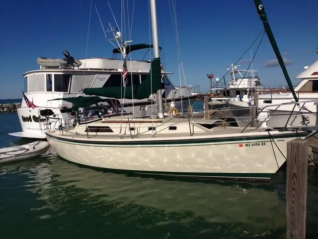 Slide: The Image of 1984 O'Day 34 Sloop sailboat docked in a marina under clear blue skies. - 0