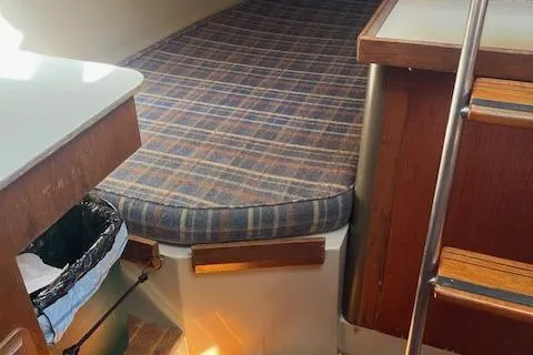 Slide: The Image of 1984 O'Day 34 Sloop interior with plaid cushion and wooden accents. - 13