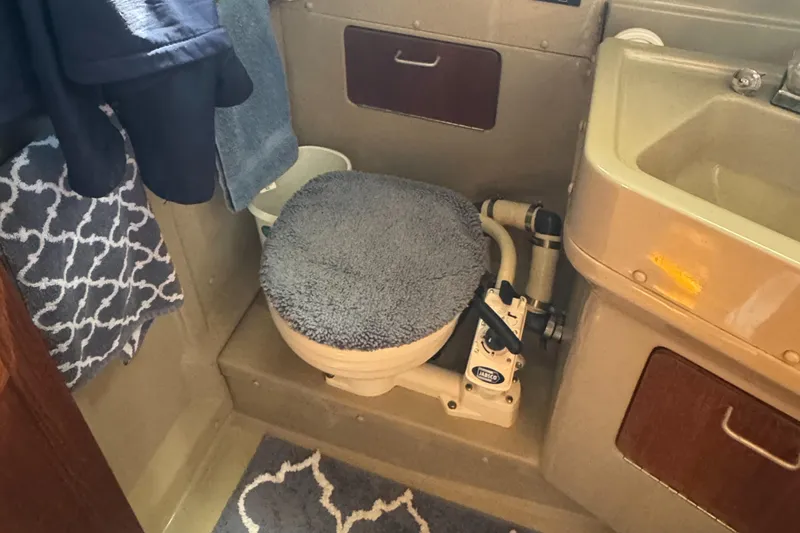 Slide: The Image of 1984 O'Day 34 Sloop bathroom with marine toilet and sink, featuring cozy decor. - 15