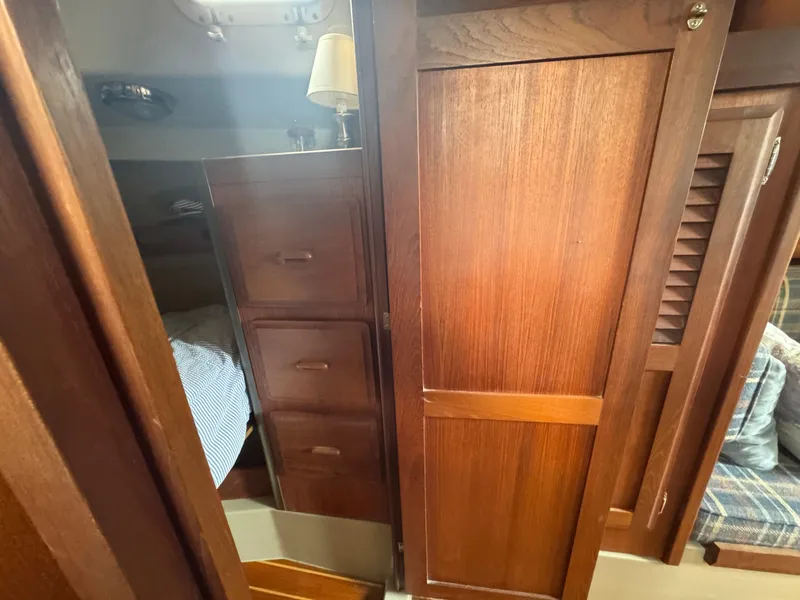Slide: The Image of Interior of 1984 O'Day 34 Sloop, featuring wooden cabinetry and cozy sleeping quarters. - 16