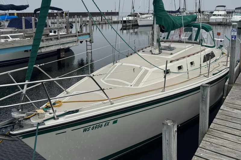 Slide: The Image of 1984 O'Day 34 Sloop docked at marina, featuring green sail cover. - 2