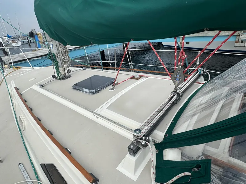 Slide: The Image of 1984 O'Day 34 Sloop sailboat deck with green sail cover and rigging at marina. - 26