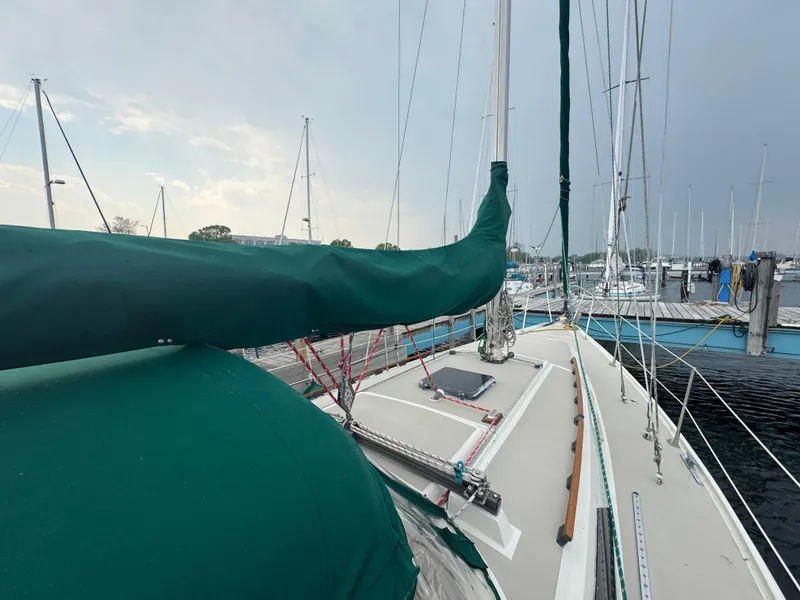 Slide: The Image of 1984 O'Day 34 Sloop sailboat docked, featuring green sail cover and deck view. - 30