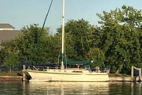 Slide: The Image of 1984 O'Day 34 Sloop sailboat docked by trees on a sunny day. - 36