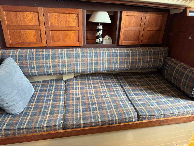Slide: The Image of 1984 O'Day 34 Sloop interior with plaid seating and wooden cabinets. - 5