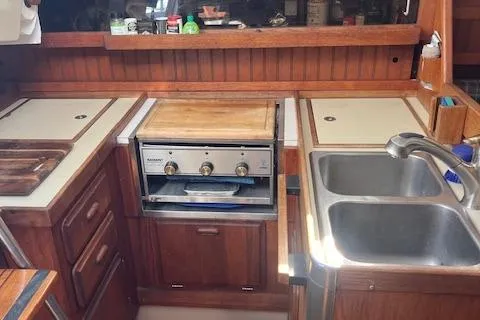 Slide: The Image of 1984 O'Day 34 Sloop kitchen with stove, sink, and wooden cabinetry. - 6