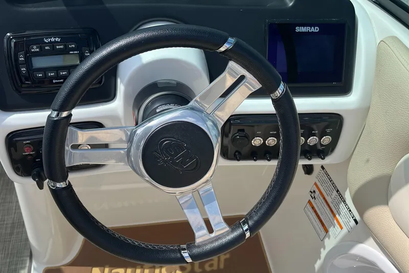 Slide: The Image of Steering wheel of 2018 NauticStar 243DC Sport Deck with control panel and Simrad display. - 14