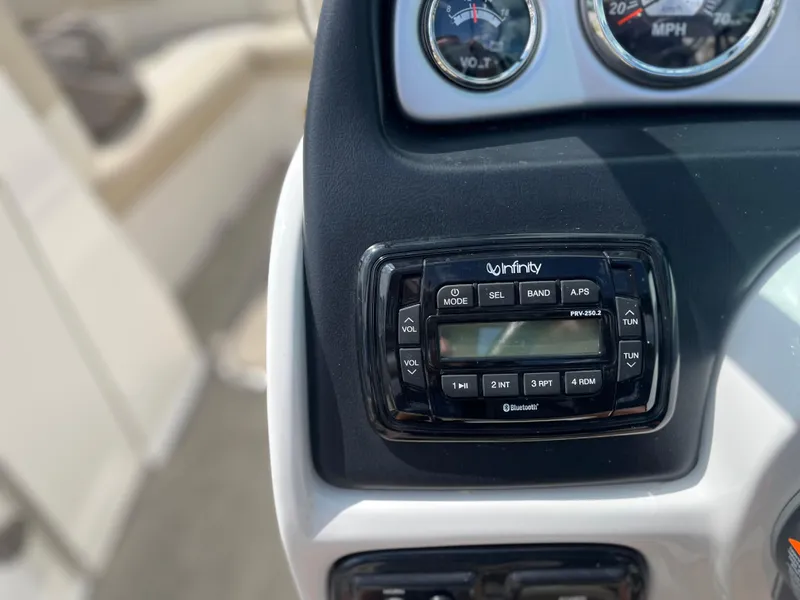 Slide: The Image of 2018 NauticStar 243DC Sport Deck dashboard with Infinity audio system and gauges. - 17