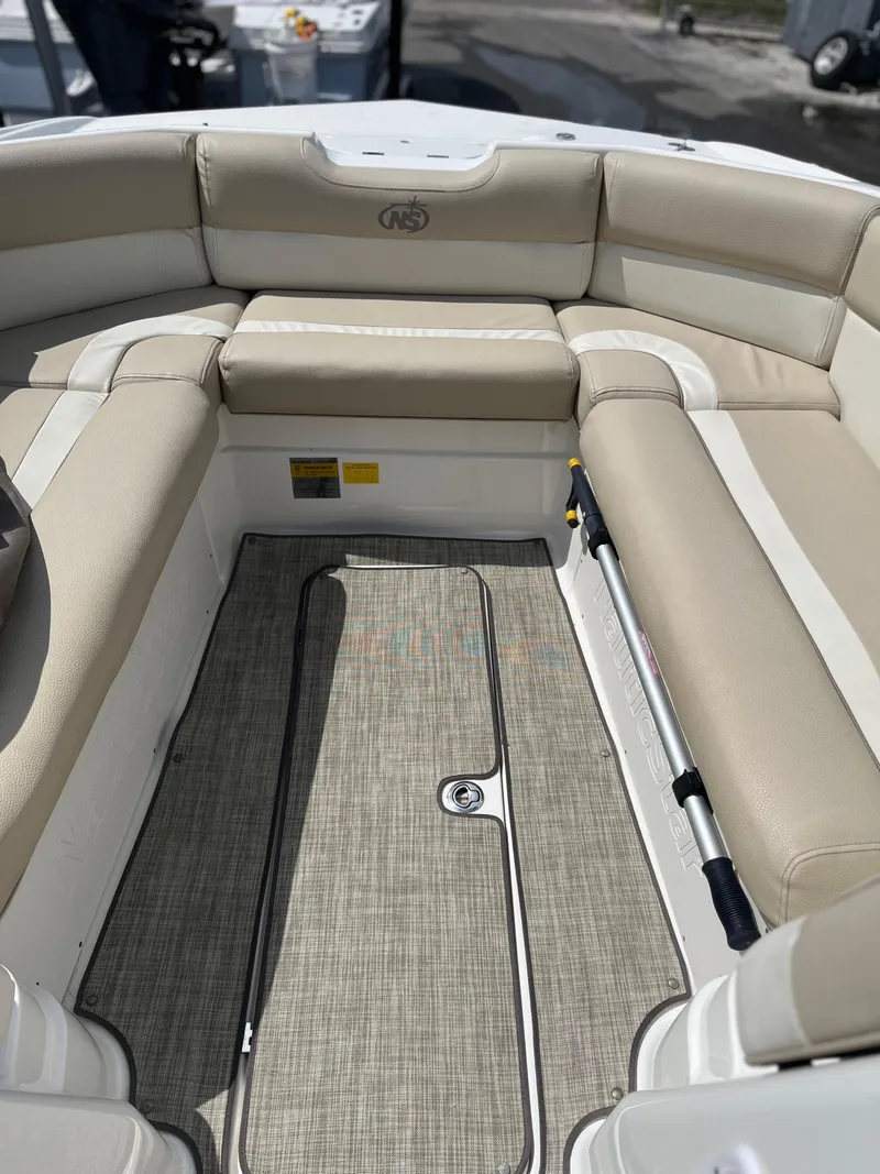 Slide: The Image of 2018 NauticStar 243DC Sport Deck boat interior with beige seating and carpeted floor. - 19